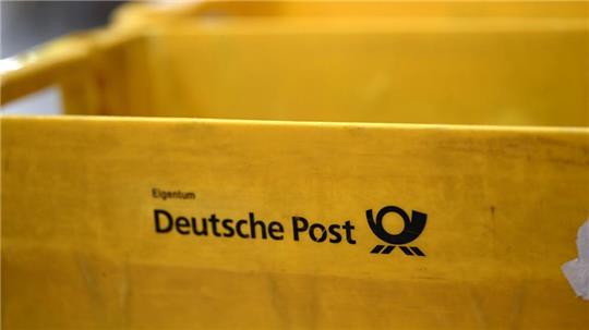 Plastikboxen der Deutschen Post stehen in einer Zustellbasis herum - auch dort könnte der Warnstreik Auswirkungen haben.