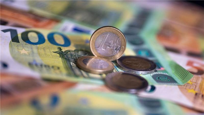 Geldscheine und Münzen liegen auf einem Tisch.