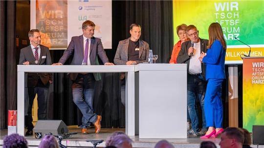 Podiumsdiskussion beim 9. Wirtschaftsforum in der Harzlandhalle in Ilsenburg: (v.r.) Moderatorin Susi Brandt befragt Foto-Dienstleister Peter Thun, Edeka-Marktleiterin Katrin Bienek, Malermeister und Photovoltaik-Unternehmer Thilo Bothe, Sachsen-Anhalts Wirtschaftsminister Sven Schulze und Marketing-Professor Marcel Lichters.