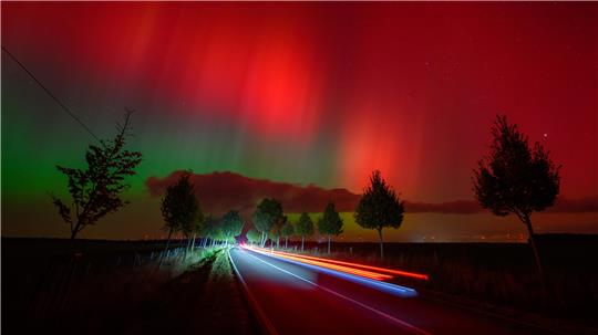 Polarlichter leuchten am Nachthimmel über einer Straße im östlichen Brandenburg – auch über dem Harz war das Spektakel zu sehen.