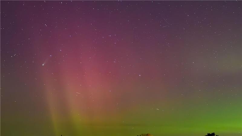Polarlichter und der Komet Lemmon „C/2025 A6“ (Bildmitte links) leuchten am Nachthimmel über der Landschaft im östlichen Brandenburg. 