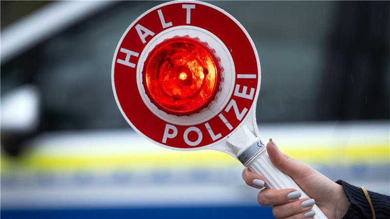 Zusehen ist eine Polizeikelle mit der Aufschrift "Halt Polizei".