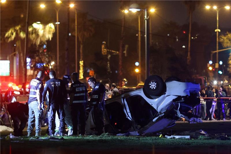 Toter und Verletzte bei mutmaßlichem Anschlag in Tel Aviv Polizei und der Rettungsdienst stehen nahe des Strands von Tel Aviv neben dem Auto, das sich überschlagen hat.