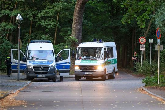 Polizeiautos fahren aus dem Wald in dem sich die Raubkatze befinden soll.