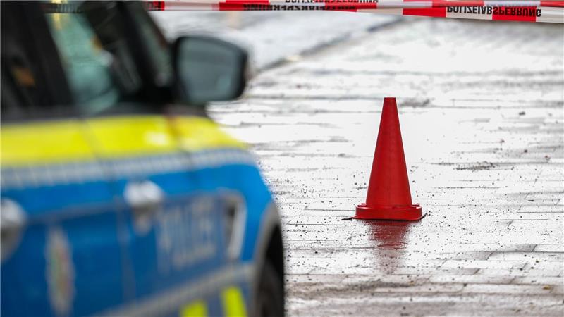 Polizeibeamte bewachen in einem Streifenwagen den Tatort.