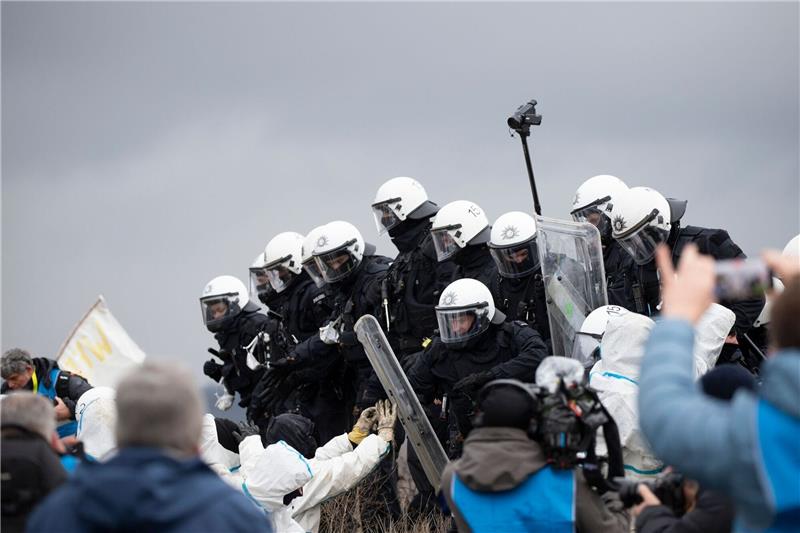 Handgemenge zwischen Aktivisten und Polizei vor Lützerath Polizeibeamte drängen Aktivisten von einem Erdwall in Lützerath zurück. Das von Aktivisten besetzte Braunkohledorf soll laut Planungen der Polizei wohl Anfang des kommenden Jahres geräumt werden.