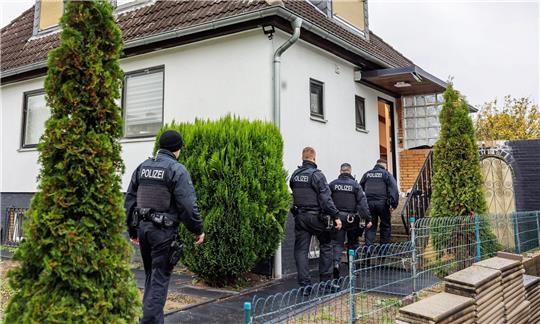 Polizeibeamte durchsuchen ein Haus in einer Wohnsiedlung in Garbsen.