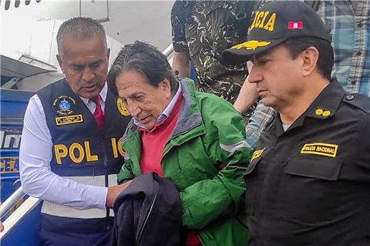 Polizeibeamte eskortieren Perus Ex-Präsident Alejandro Toledo bei seiner Ankunft am Flughafen in Lima. Er ist wegen Korruptionsvorwürfen aus den USA an sein Heimatland ausgeliefert worden.