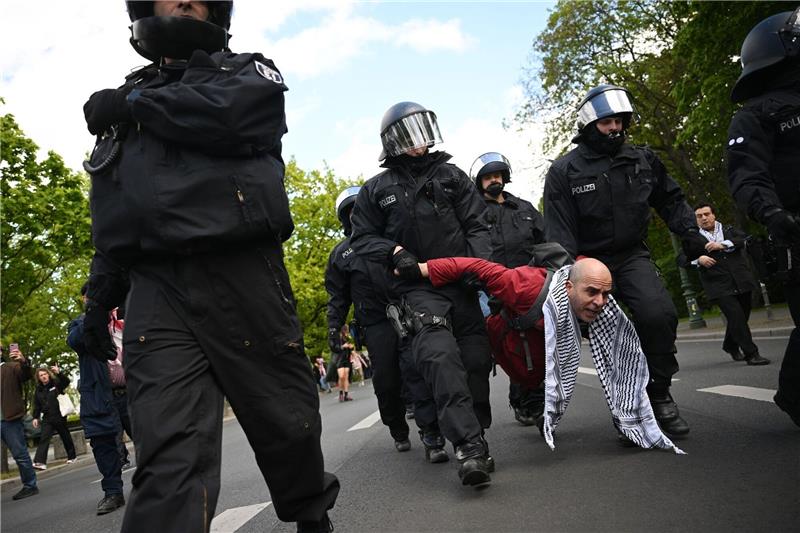 Palästina-Camp geräumt - Demonstranten werden weggeschleppt Polizeibeamte nehmen einen Teilnehmer einer Unterstützungsversammlung für das propalästinensische Protestcamp mit.