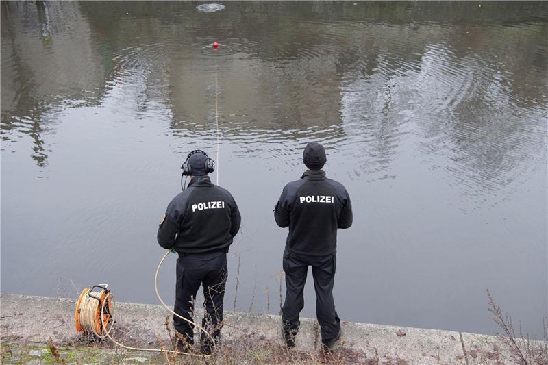 Polizeibeamte sichern vom Ufer aus einen Tauscher.