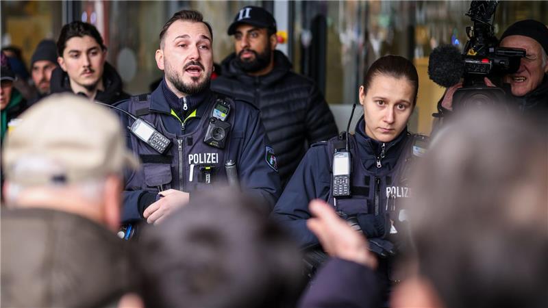 Polizeibeamte sprechen mit möglicherweise betroffenen Kunden der Sparkassenfiliale in Buer.