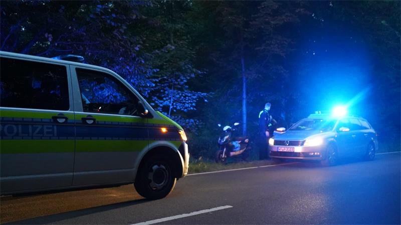 Polizeibeamte stehen am Straßenrand im Heininger Wald. Dort wurde auch der zurückgelassene Roller gefunden.