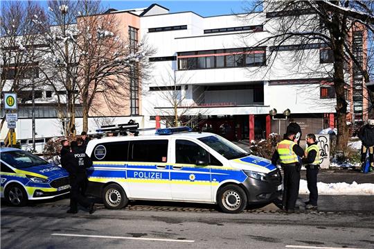 Polizeifahrzeuge und Polizisten stehen nach einem Großeinsatz an der Staatlichen Berufsschule I. in Traunstein.