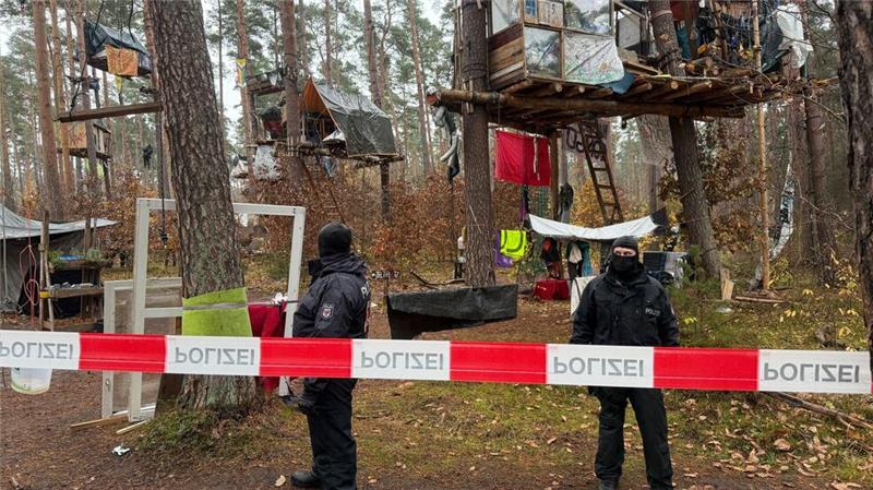 Zähe Hängepartie - Polizei löst Tesla-Protestcamp auf Polizeikräfte sichern das Waldgebiet hinter einer Absperrung. Umweltaktivisten, die gegen Tesla protestieren, müssen ihr Camp räumen.