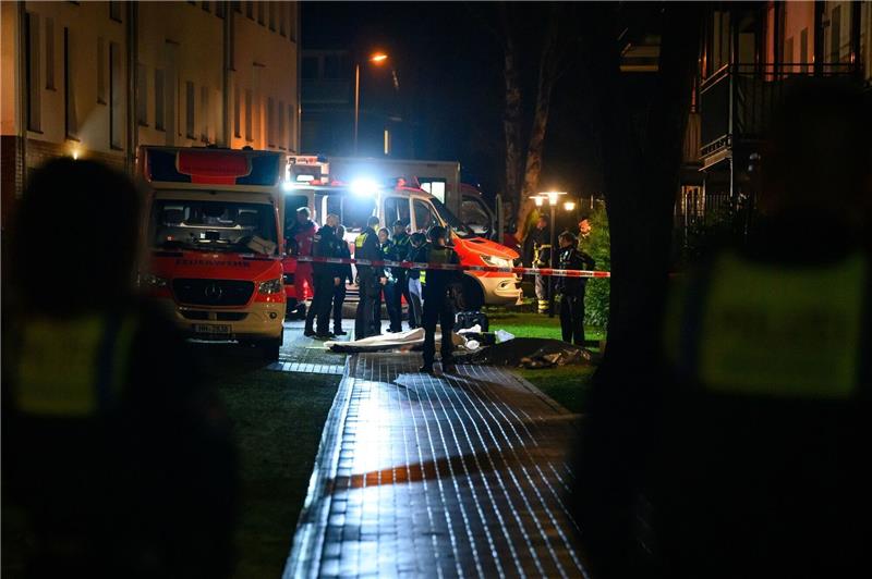 Zwei Tote nach Schüssen in Hamburg Polizisten, Ermittler und Rettungskräfte stehen am Tatort neben zwei abgedeckten Leichen.