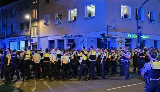 Polizisten bewachen mutmaßliche Teilnehmer einer Massenschlägerei in der Essener Innenstadt.