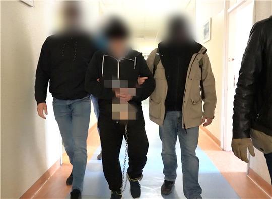 Polizisten bringen den mutmaßlichen Doppelmörder (M) zur Vernehmung bei der Bezirksstaatsanwaltschaft Warschau.