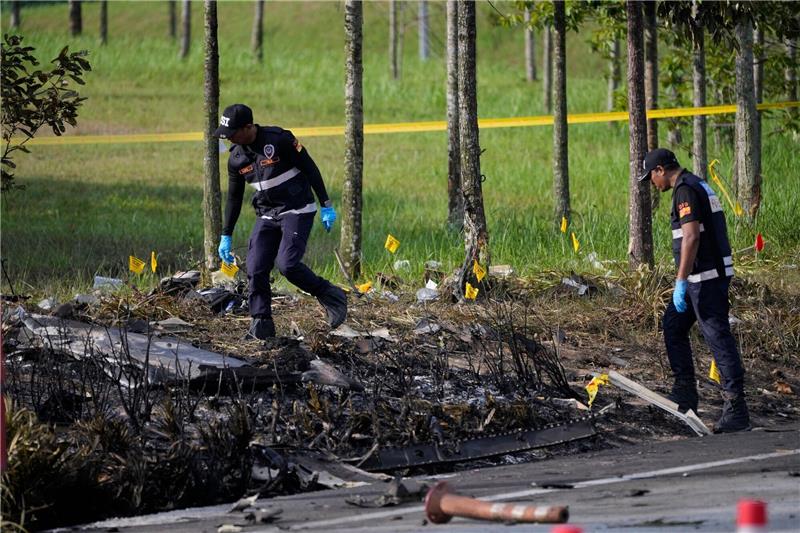 Polizisten ermittelt an der Absturzstelle des Kleinflugzeugs in Malaysia.