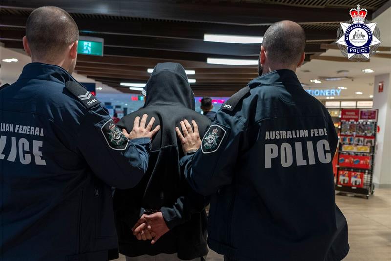 Einer der größten Heroin-Schmuggler in Australien gefasst Polizisten führen den Schmuggler ab.