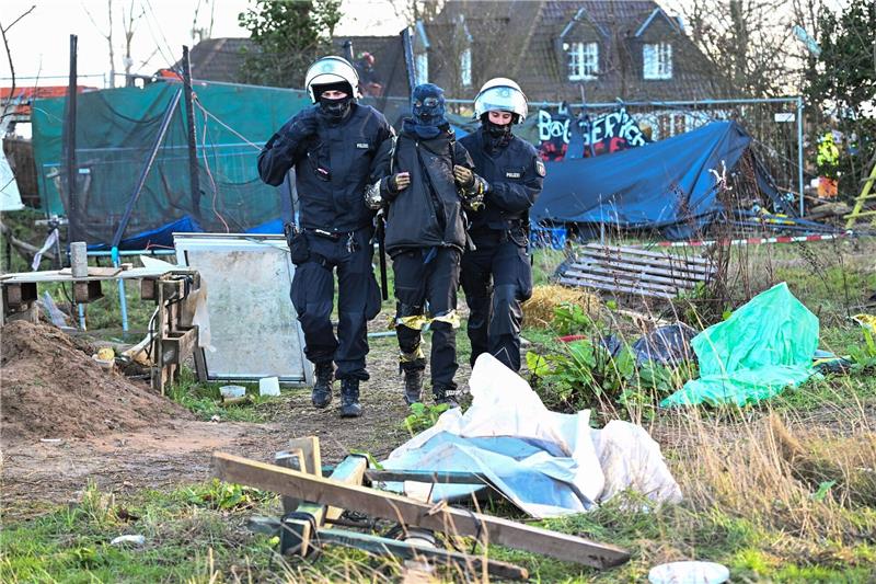Bundestag debattiert über Lützerath-Einsatz Polizisten führen einen Klimaaktivisten in Lützerath vom Gelände.