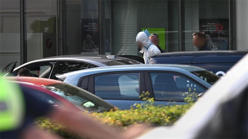 Polizisten führten am Abend einen Mann in einem weißen Anzug aus dem Gebäude, wenig später wurde eine Festnahme vermeldet.