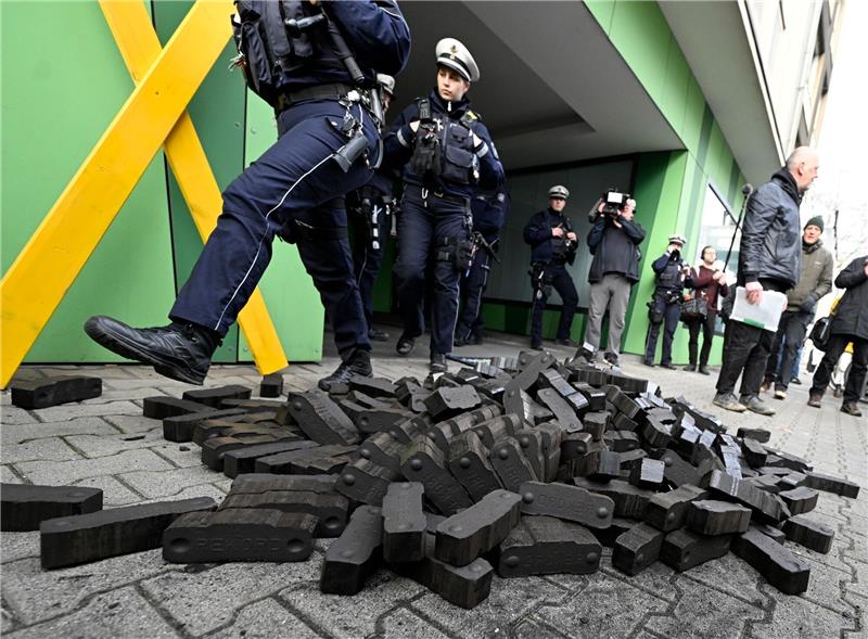 Klimaschützer kippen Braunkohle vor Grünen-Parteizentrale Polizisten gehen über einen Kohlehaufen, den Aktivisten verschiedener Umweltschutzgruppen vor der Grünen Parteizentrale in Nordrhein-Westfalen hingeworfen haben.