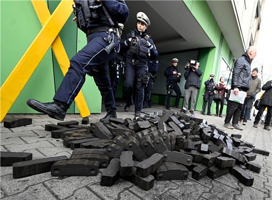 Polizisten gehen über einen Kohlehaufen, den Aktivisten verschiedener Umweltschutzgruppen vor der Grünen Parteizentrale in Nordrhein-Westfalen hingeworfen haben.