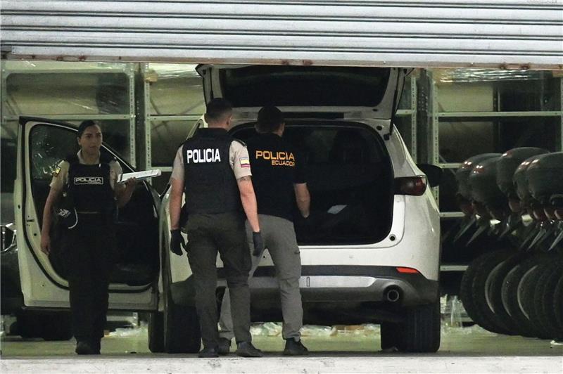 Bandenkämpfe in Ecuador: Leitender Staatsanwalt getötet Polizisten in Schutzwesten untersuchen das Auto des erschossenen Staatsanwalts César Suárez.