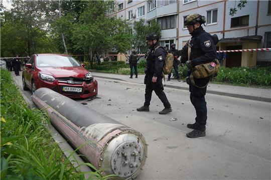 Polizisten inspizieren einen Teil einer russischen Rakete, die in der Nähe eines Wohnhauses in Charkiw eingeschlagen ist.