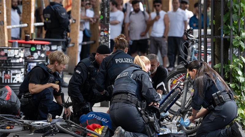Polizisten knien in der Nähe des Frankfurter Hauptbahnhofs am Boden und kümmern sich um einen Verletzten. 