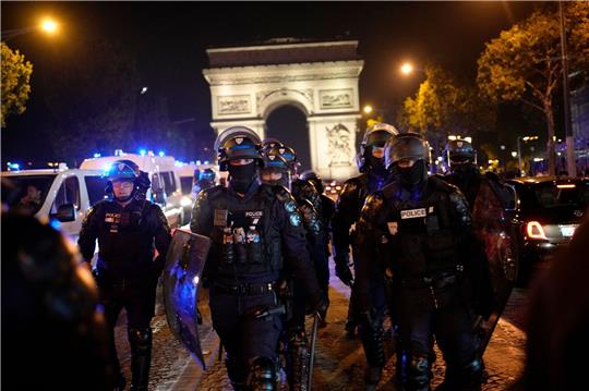 Polizisten patrouillieren vor dem Arc de Triomphe auf der Champs Élysées.