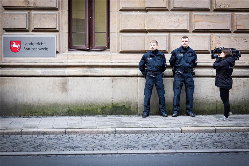 Schöffin befangen? – Prozesstag gegen Christian B. endet abrupt Polizisten stehen am Tag des Prozessbeginns gegen den Angeklagten Christian B. vor dem Landgericht und werden von einer Kamerafrau gefilmt. Foto: picture alliance/dpa | Moritz Frankenberg