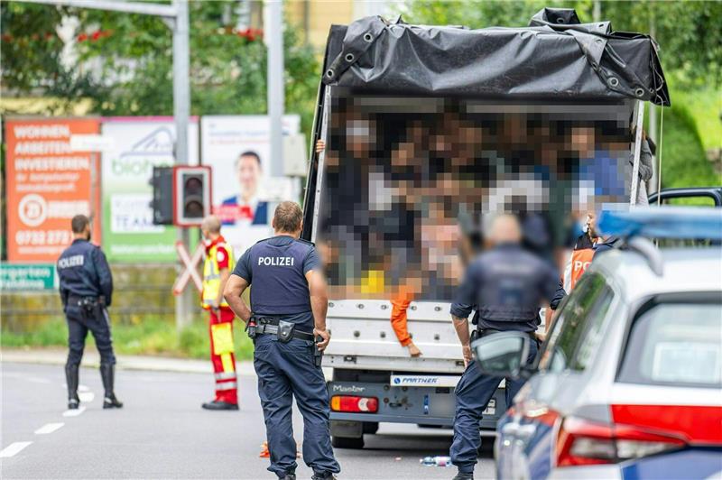Menschenschmuggel: Lkw mit 53 Menschen in Linz gestoppt Polizisten stehen bei einer Kontrolle in Österreich an einem Kleintransporter. Die Beamten entdeckten dabei 53 Personen auf der Ladefläche.