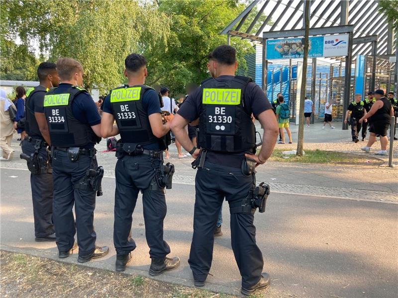 Hoher Krankenstand nach Randale: Columbiabad geschlossen Polizisten stehen vor dem Eingang des Sommerbads in Neukölln.