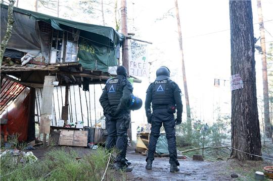 Polizisten stehen vor einem Baumhaus der Initiative «Heibo bleibt» in einem besetzten Waldgebiet in der Laußnitzer Heide. Im Heidebogen haben sich seit etwa eineinhalb Jahren Klimaaktivisten und Naturschützer verschanzt, um gegen den Kiesabbau zu protestieren