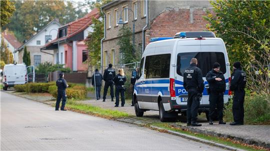 Polizisten stehen vor einem Grundstück in Herzberg.