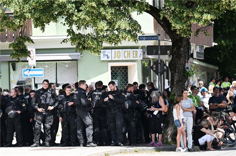 Polizisten suchen bei der Kundgebung vor der Demonstration des Bündnisses «Stop G7 Elmau» Schatten unter einem Baum.
