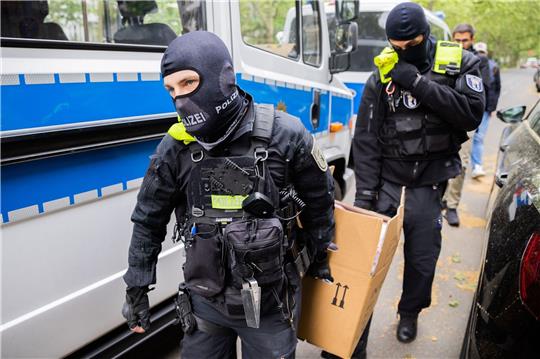 Polizisten tragen bei einer Hausdurchsuchung in Berlin-Kreuzberg einen Karton zu einem Fahrzeug. Ein halbes Jahr nach umfangreichen Durchsuchungen bei der Letzten Generation hat das Landgericht München I zahlreiche Beschwerden gegen die Razzia größtenteils abgewiesen.