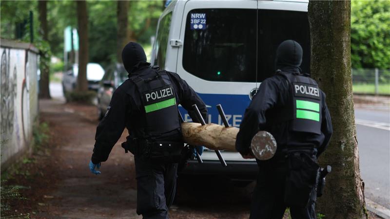 Polizisten tragen einen Rammbock.