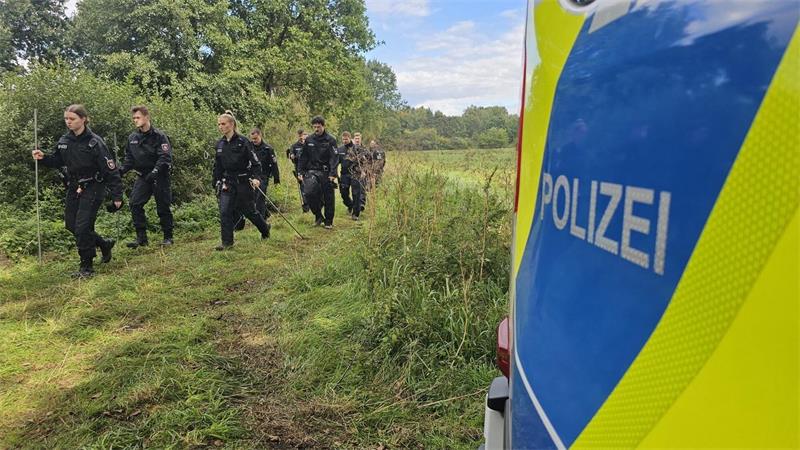 Polizistinnen und Polizisten auf der Suche nach Drohnenteilen in Wunstorf. (Archivbild)