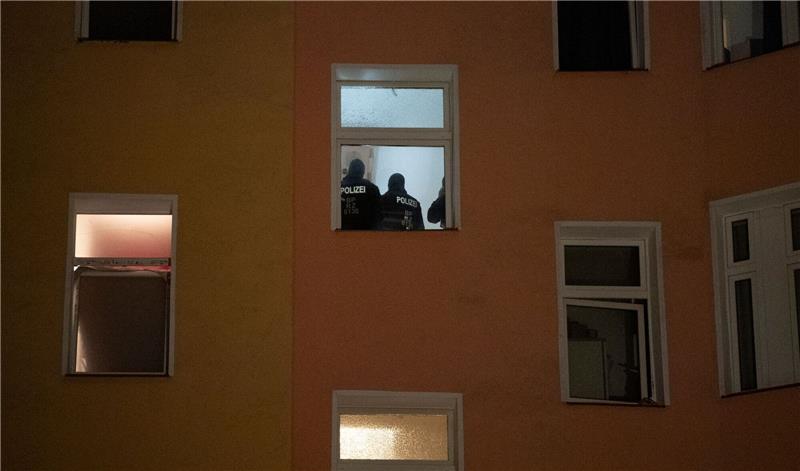 Polizten sind am Morgen im Treppenhaus eines Wohnhauses zu sehen.