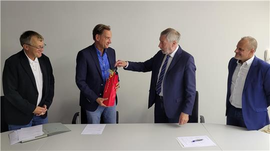 Präsent zur Vertragsunterzeichnung: Die KTW-Aufsichtsratsmitglieder Thomas Ebert und Ralf Abrahms (v.re.) sowie der scheidende Geschäftsführer Bernd Vollrodt (l.) begrüßen Christian Klamt.