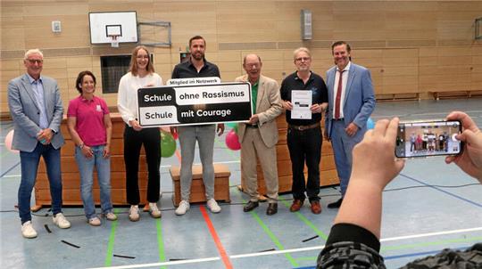 Präsentieren das Schild, das das Jacobson-Gymnasium als Teil des Netzwerks ausweist, für Erinnerungsfotos (v.l.): Bodo Mahns, Sylke Besser, Nieke Kühne, Felix Brandt, Michael Fürst, Stefan Bungert und Torsten Glaser.