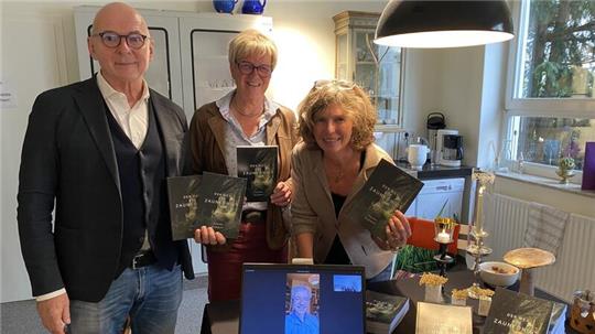 Präsentieren gemeinsam den frisch erschienen, selbst verlegten Titel „Der Weg des Zaunkönigs“: Lektor Hartmut Frenk, Übersetzerin Petra Nietsch und Sonja Weber von der Bücher-Heimat. Auf dem Bildschirm zugeschaltet ist Autor Philipp Schott.