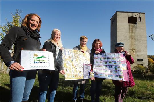 Präsentieren im Schatten des alten Verladebunkers der Grube das Logo der ILE-Region sowie Vorder- und Rückseite der neuen Stempelstellenkarte (v.li.): Jessica Lau (Tourismusverband), Alexandra Klotz (Goslar Marketing GmbH), Sandra Armbrecht (Gemeinde Liebenburg), Irene Schneider (Amt für Tourismus in Hornburg), Daniela Happ (Stadt Salzgitter). Fotos: Gereke