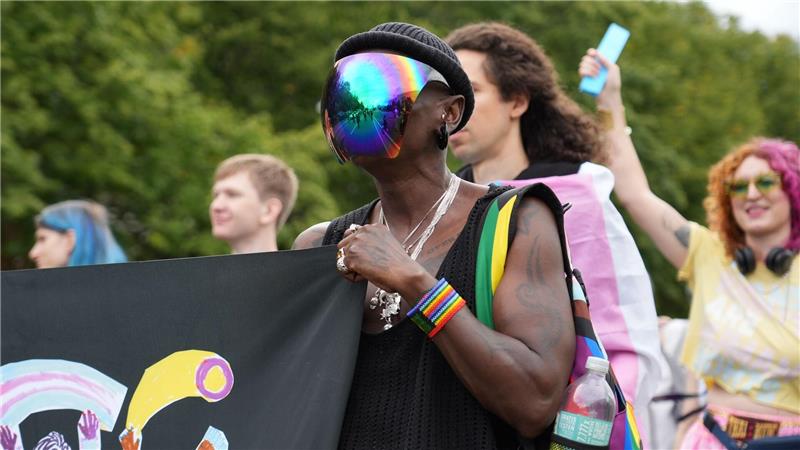 Pride-Demo: Ein Teilnehmer trägt ein bunt schillerndes Visier bei einer Demonstration in Berlin unter dem Motto: „Inta* Pride Berlin 2025 - we exist!“.
