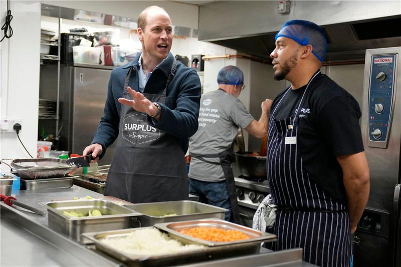 Prinz William (l) hilft dem Chefkoch Mario Confait bei der Herstellung von Bolognese-Sauce.