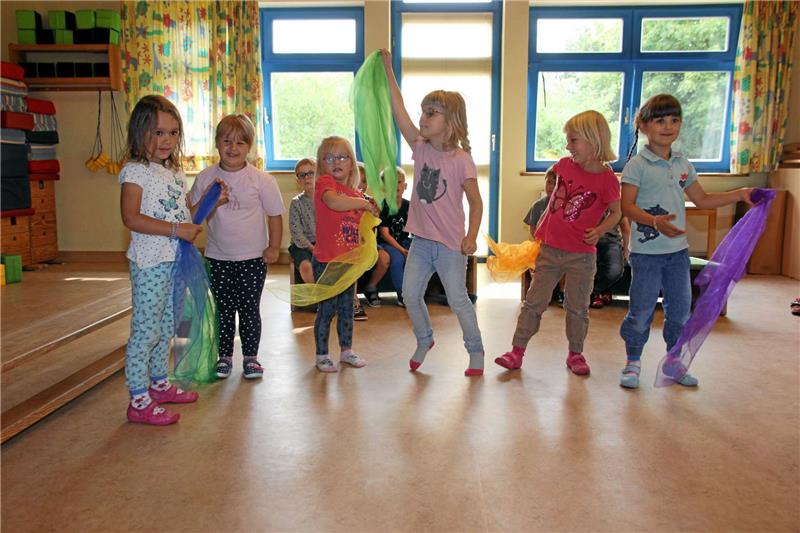 Proben fleißig für die 25-Jahr-Feier des Kindergartens in Hahausen: Die Mädchen aus der Hasengruppe treten am Samstag mit bunten Tüchern auf. Fotos: Haberstumpf