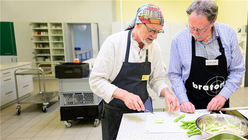 Profikoch Winfried Marx leitet einen Witwer beim Kochen an.  