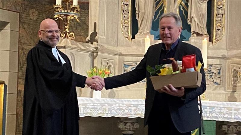 Propst Jens Höfel gratuliert Küster Jakob Hinkel zum Dienstjubiläum.